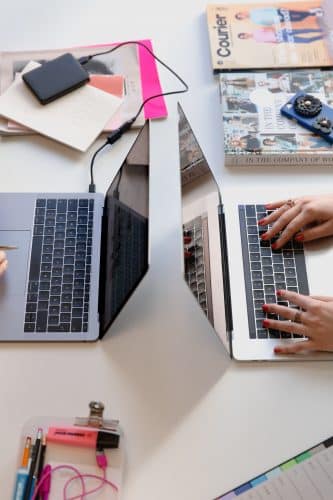Humans sitting at a shared table and searching for websites.